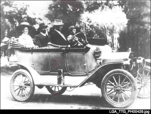 Mr and Mrs Richard Smith driving their new Ford car